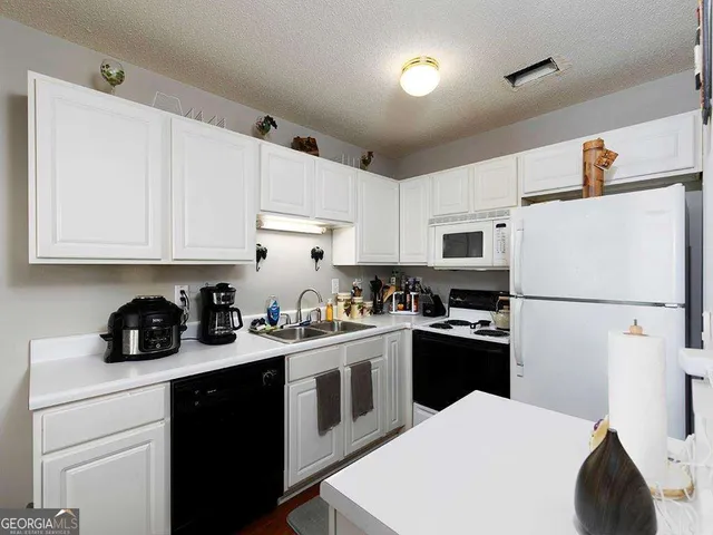 a kitchen with a white cabinets and white appliances