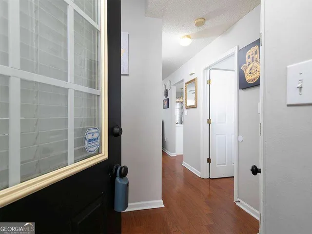 a view of a hallway with wooden floor and windows
