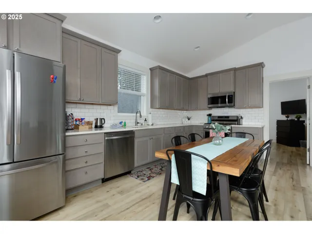 a kitchen with a dining table chairs refrigerator and cabinets