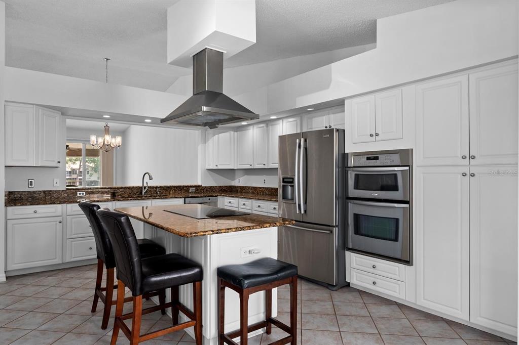 1227 Clays Trail Oldsmar, FL 34677 - Photo 13 of 37 a kitchen with granite countertop a center island stainless steel appliances and cabinets