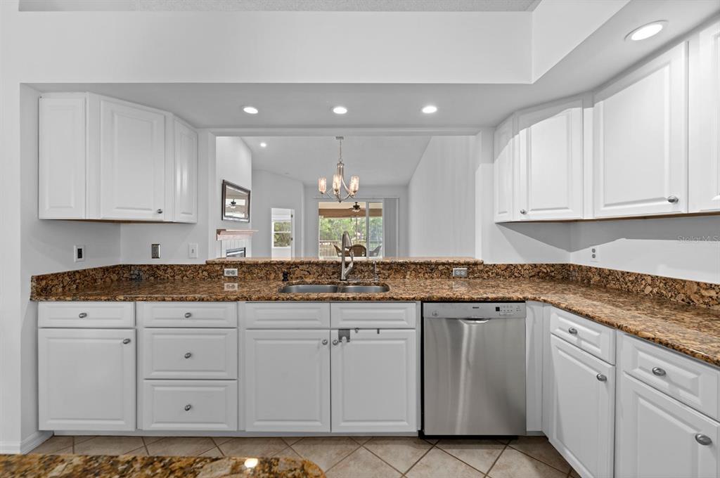 1227 Clays Trail Oldsmar, FL 34677 - Photo 14 of 37 a kitchen with granite countertop white cabinets and a sink