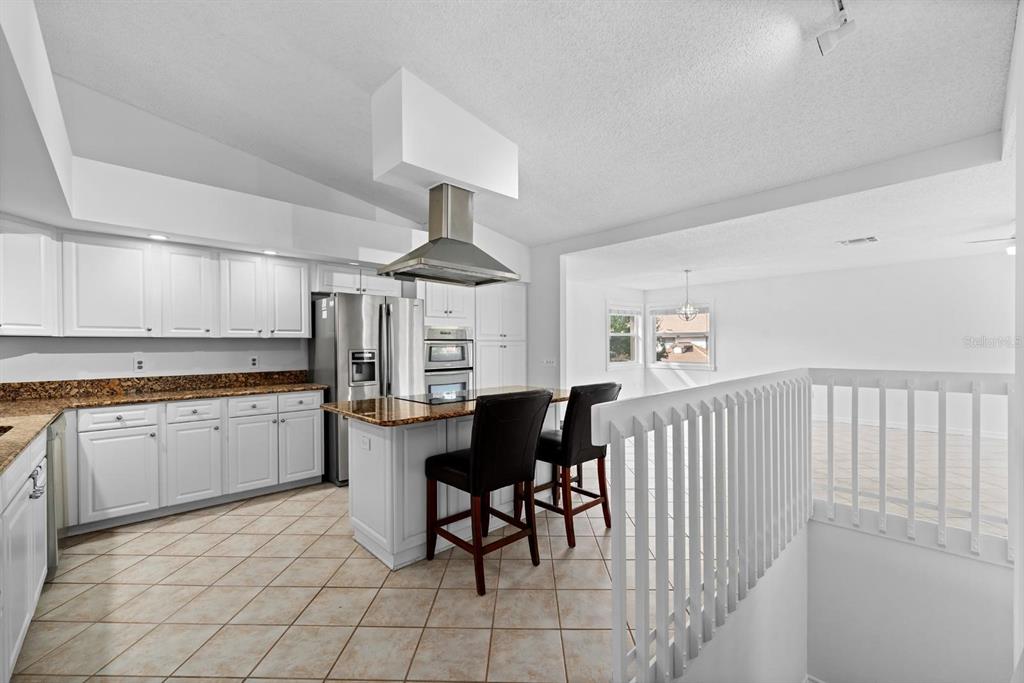 1227 Clays Trail Oldsmar, FL 34677 - Photo 5 of 37 a kitchen with granite countertop sink a table and chairs in it