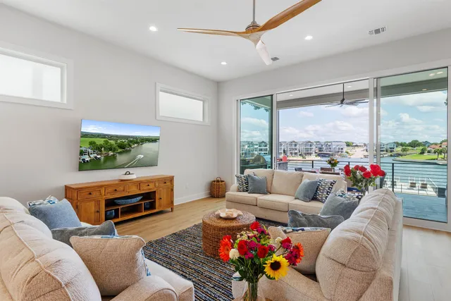 a living room with furniture a rug and a floor to ceiling window