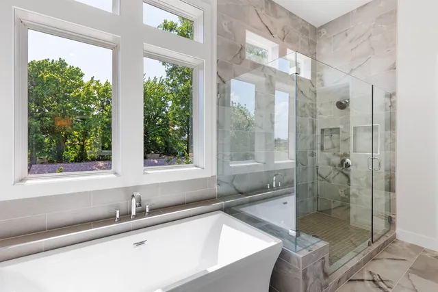 a bathroom with a granite countertop tub next to a window