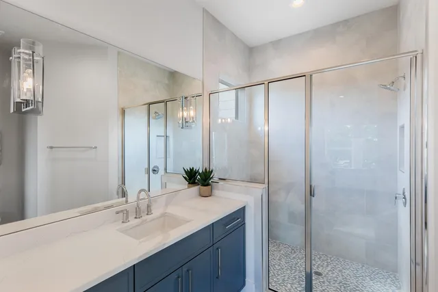 a bathroom with a shower sink vanity and mirror