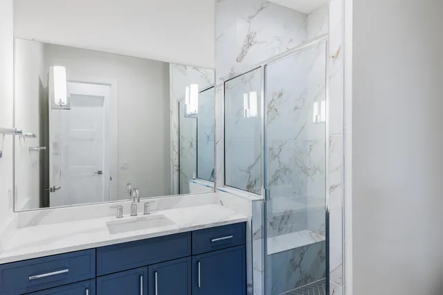 a bathroom with a shower sink and mirror