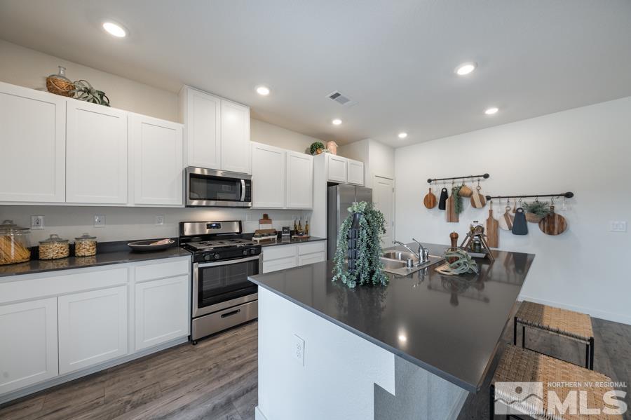 508 Russell Road, Unit LOT #96 Dayton, NV 89403 - Photo 9 of 17 a kitchen with stainless steel appliances granite countertop a sink a stove and cabinets