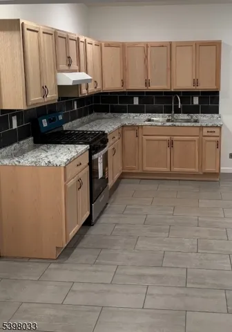 a kitchen with stainless steel appliances granite countertop a sink a stove and cabinets