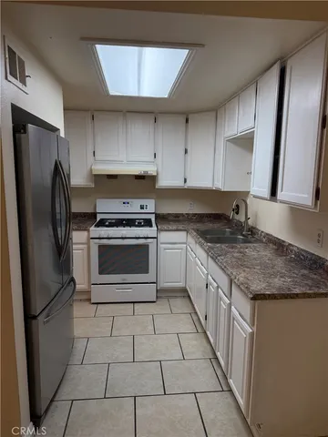 a kitchen with stainless steel appliances granite countertop a stove a refrigerator and a sink