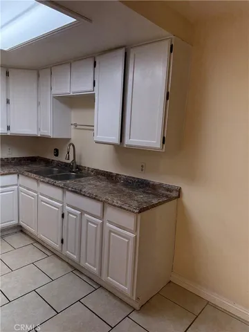 a kitchen with granite countertop a sink and cabinets