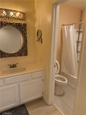 a bathroom with a granite countertop sink toilet and a mirror