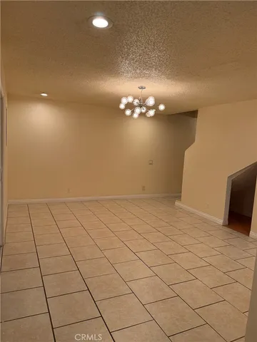 a view of a livingroom with an empty space and a chandelier fan