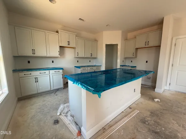 a kitchen with granite countertop a sink a stove a refrigerator and white cabinets