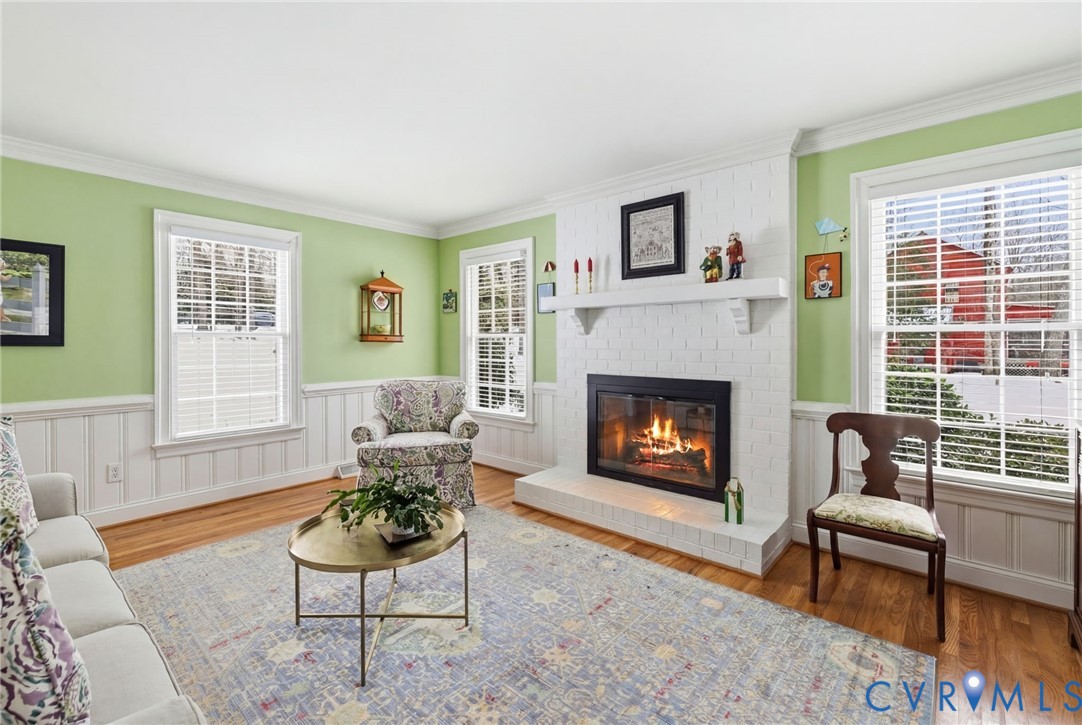 13111 Powderham Lane Midlothian, VA 23113 - Photo 12 of 37 Brick fireplace, hardwood floors, and wainscoting.