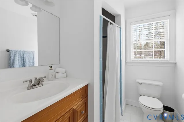 a bedroom with a bed a window and a flat screen tv