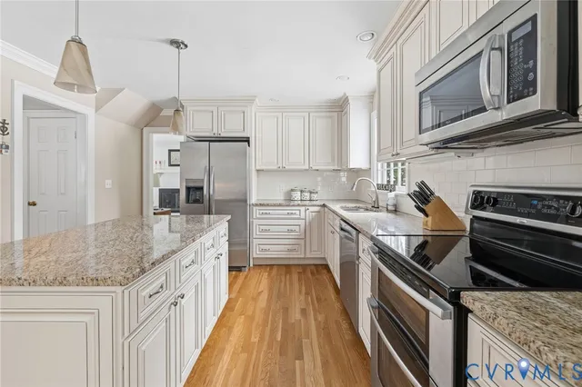 a kitchen with stainless steel appliances granite countertop a sink and a stove