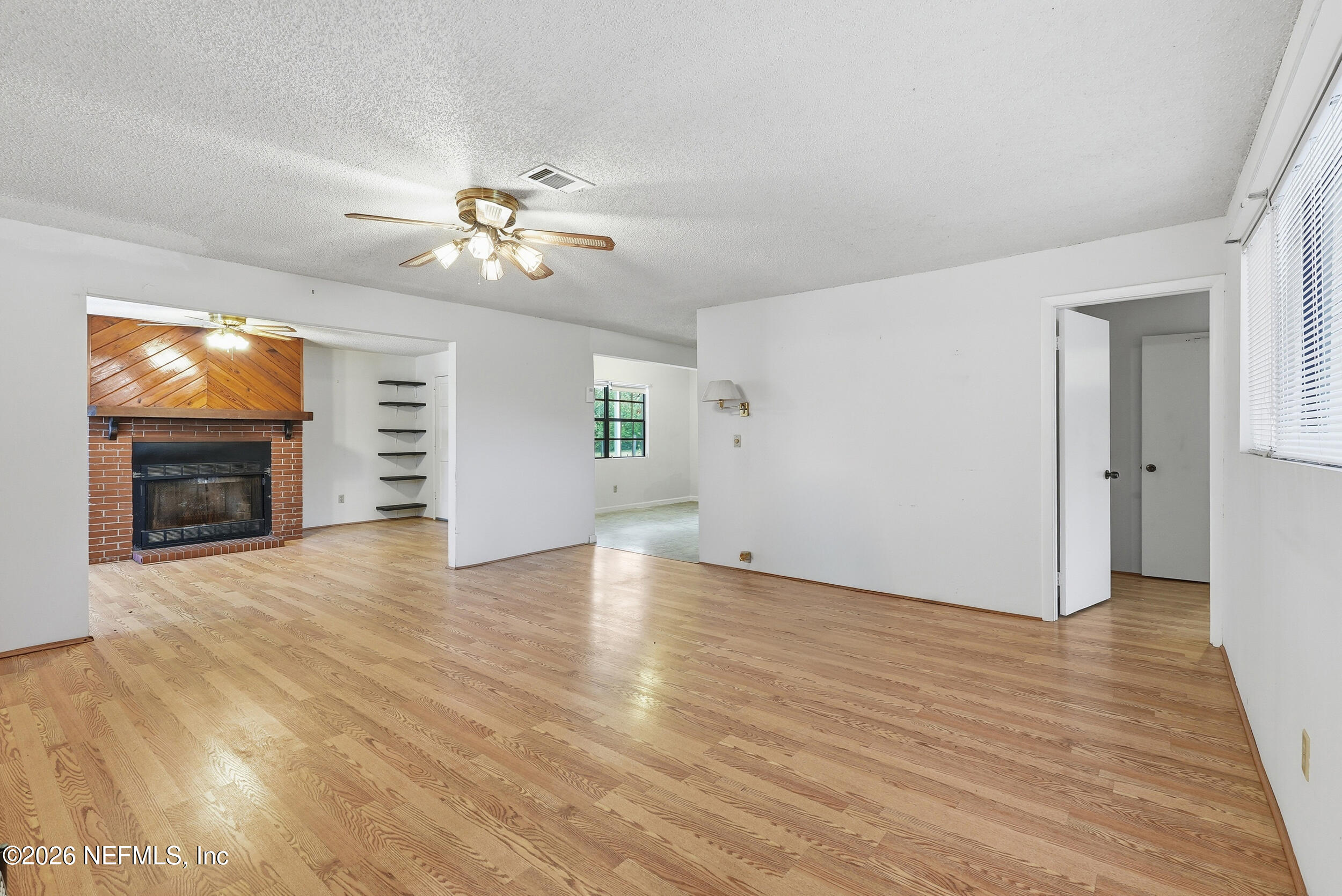 7593 Silver Sands Road Keystone Heights, FL 32656 - Photo 8 of 36 a view of empty room with wooden floor and fireplace