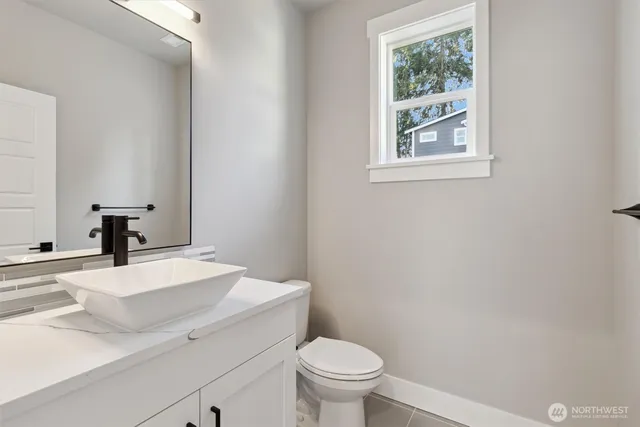 a bathroom with a sink a toilet and a window