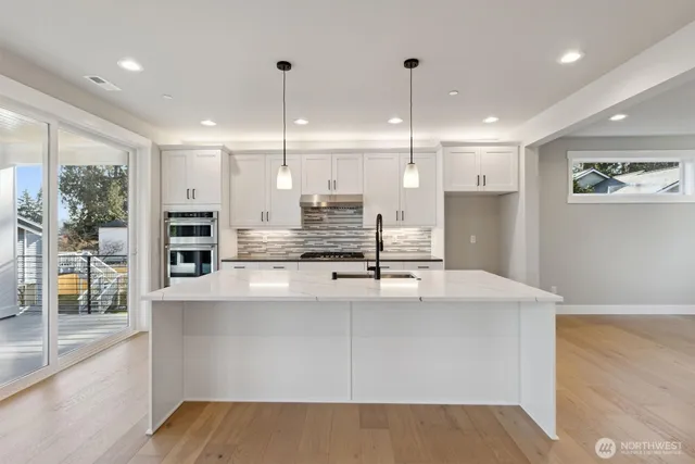 a large kitchen with stainless steel appliances kitchen island a large counter top