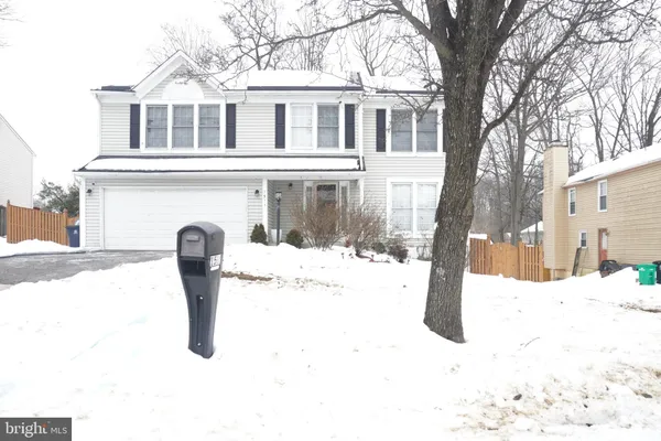 a front view of a house with a yard covered in snow