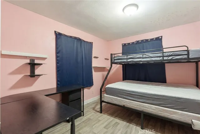 a spacious bedroom with a bed and wooden floor