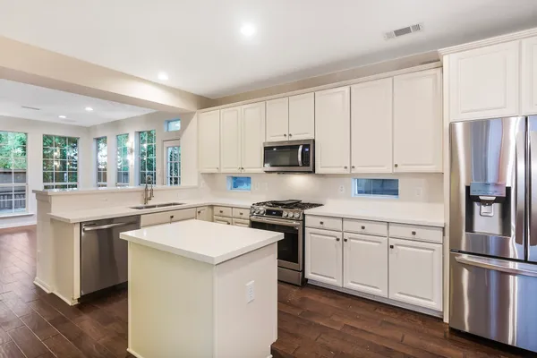 a kitchen with white cabinets and stainless steel appliances