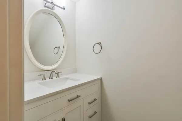 a bathroom with a sink mirror and vanity