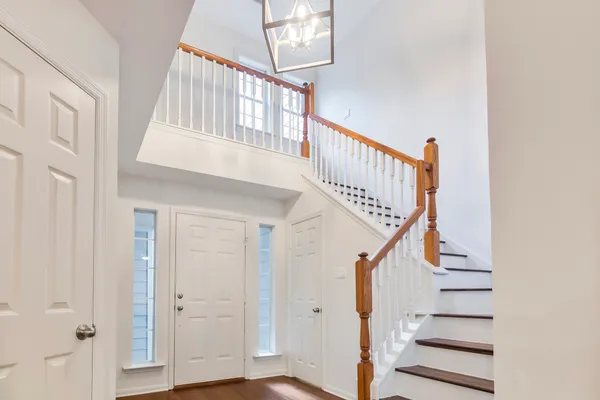 a view of staircase with railing and white walls