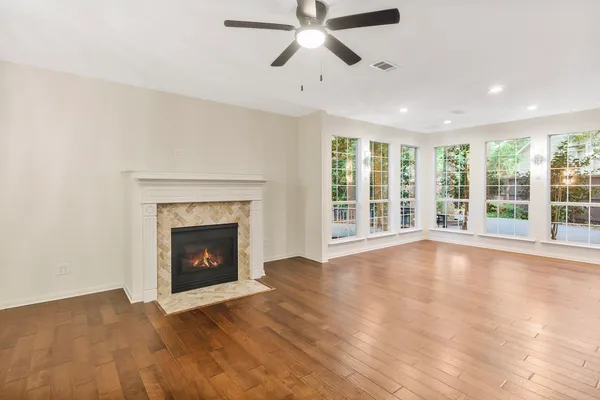 a view of an empty room with window and wooden floor