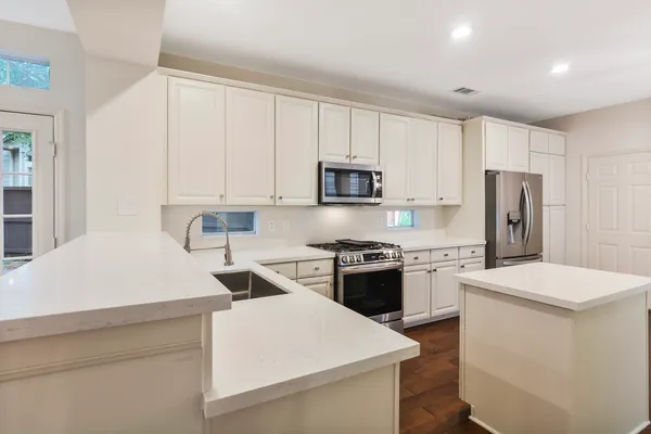 a kitchen with stainless steel appliances a refrigerator sink and stove