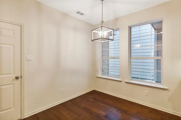 a view of empty room with wooden floor and window