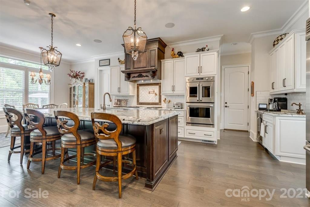 2886 Holbrook Road Fort Mill, SC 29715 - Photo 6 of 34 a large kitchen with stainless steel appliances kitchen island granite countertop a table chairs and a refrigerator