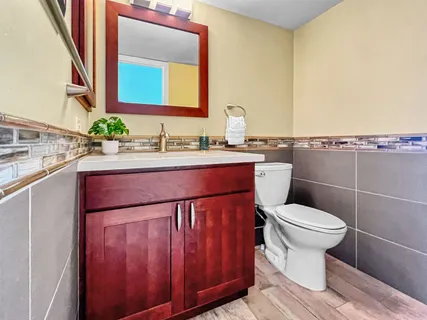 a bathroom with a toilet a sink and mirror