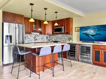 a kitchen with stainless steel appliances kitchen island granite countertop a table chairs in it and wooden floors