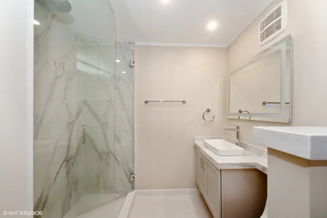 a bathroom with a granite countertop sink a toilet and shower