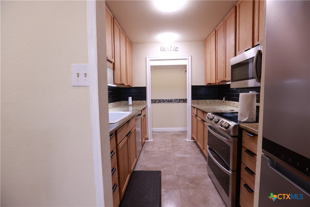 2706 Bowie Trail Temple, TX 76502 - Photo 13 of 25 a kitchen with stainless steel appliances a refrigerator a stove top oven a sink and dishwasher