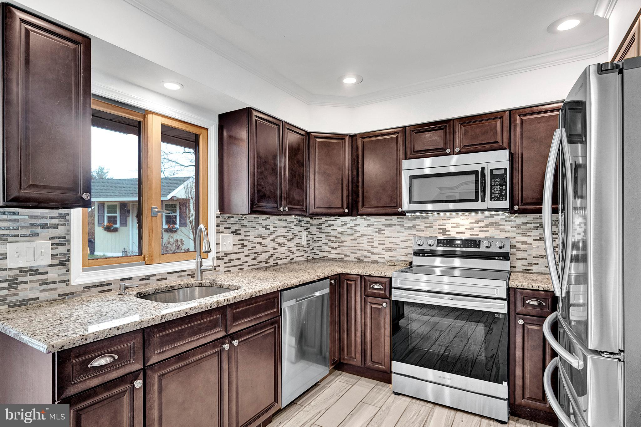 6 Unity Turn Levittown, PA 19056 - Photo 13 of 50 a kitchen with stainless steel appliances granite countertop a stove microwave and sink
