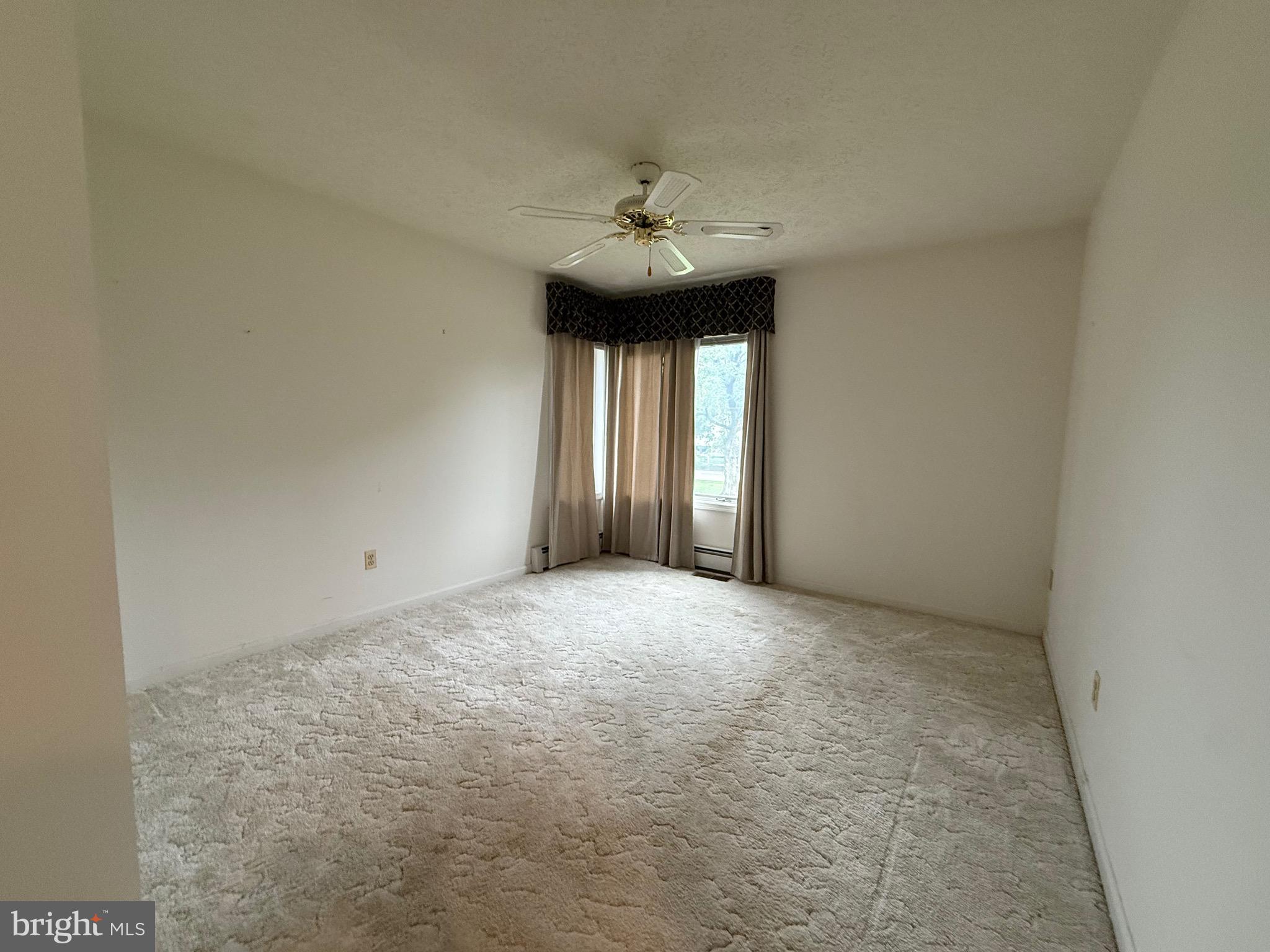 7252 Meadow Lane Baltimore, MD 21222 - Photo 62 of 80 an empty room with a chandelier fan and windows