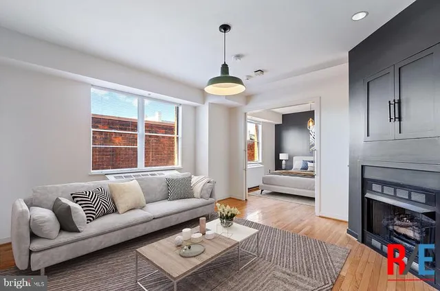 a living room with furniture a fireplace and a chandelier