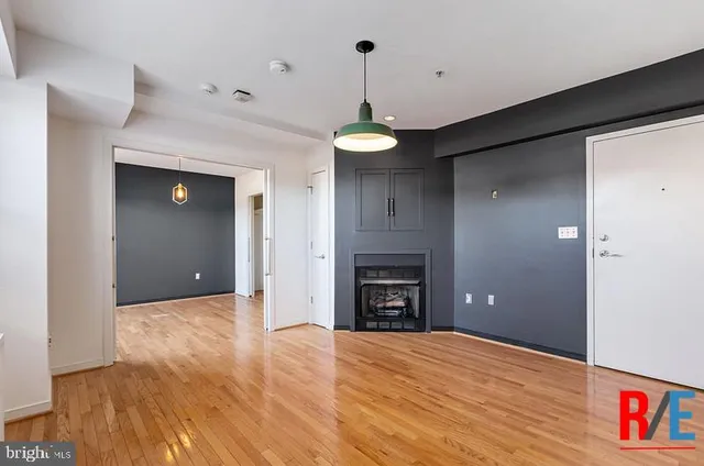 a view of empty room with a fireplace and wooden floor
