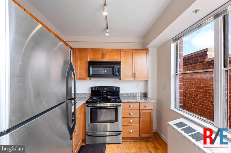 815 King Street, Unit 4E Alexandria, VA 22314 - Photo 8 of 27 a kitchen with stainless steel appliances granite countertop a stove a sink and a refrigerator