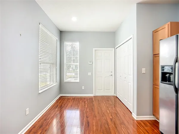 a view of empty room with wooden floor and fan