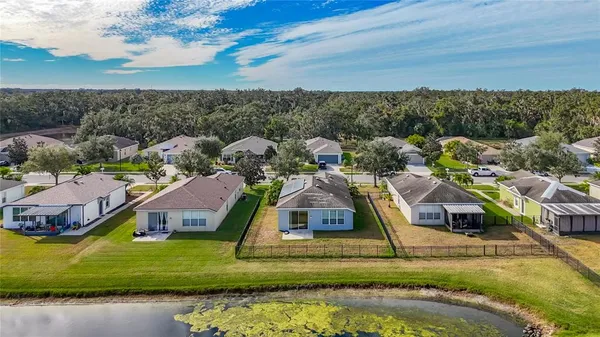 a aerial view of a house with a big yard and large trees