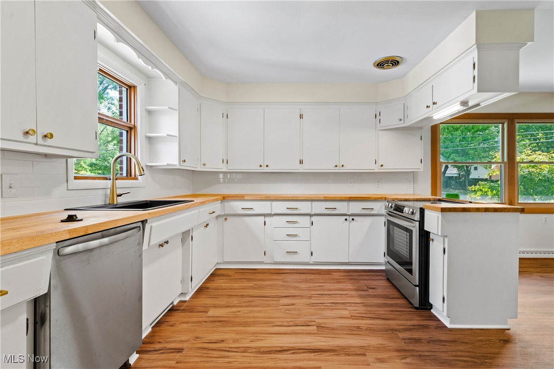 870 Trebisky Road Cleveland, OH 44121 - Photo 11 of 48 Kitchen with appliances with stainless steel finishes, light wood-type flooring, white cabinetry, and sink