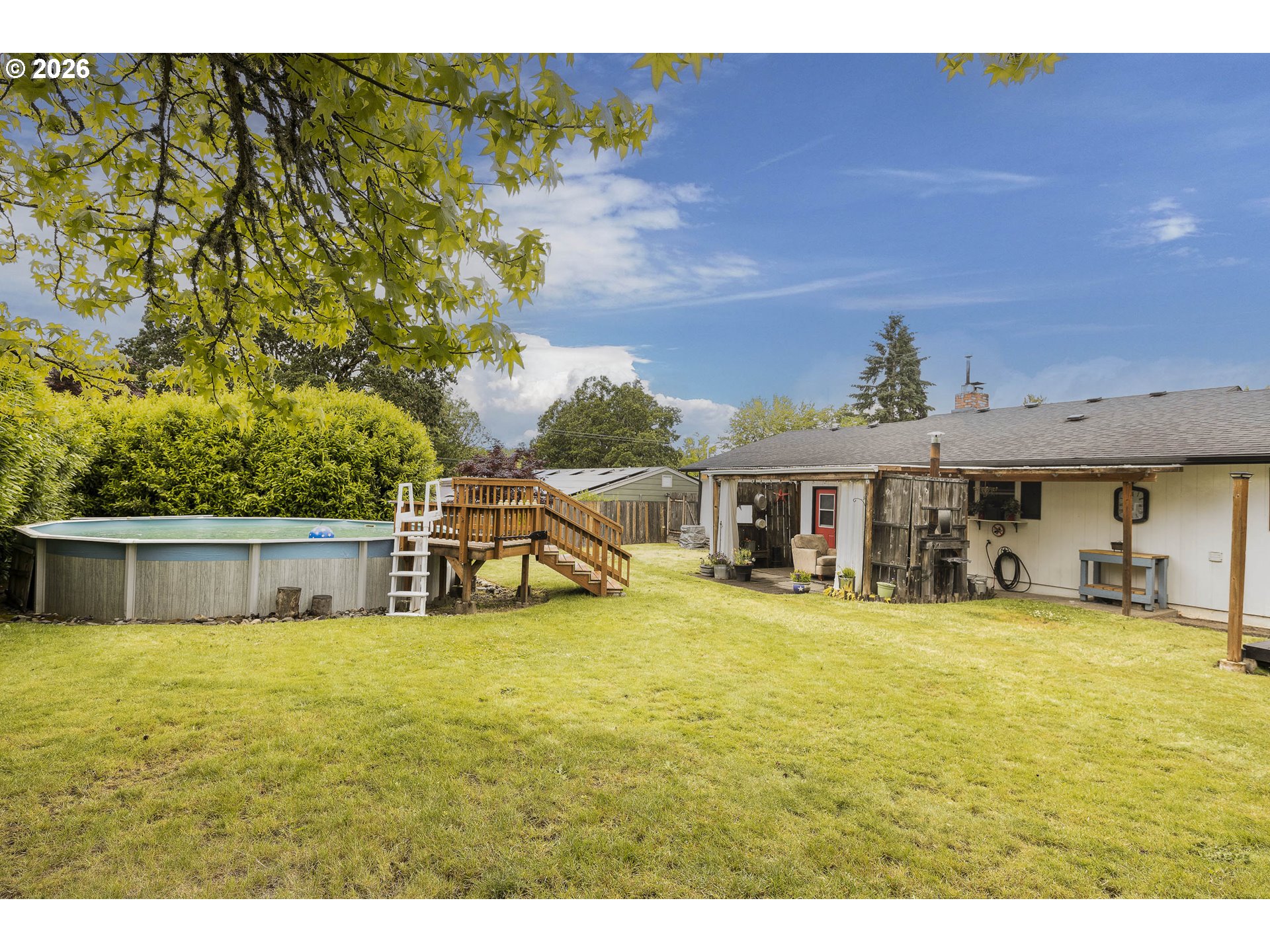 18430 Southwest Broad Oak Boulevard Aloha, OR 97007 - Photo 31 of 32 a view of a swimming pool with lawn chairs and large trees