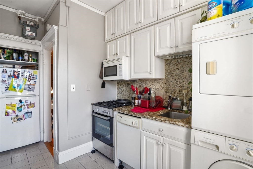 8 Garrison Street, Unit 706 Boston, MA 02116 - Photo 9 of 14 a kitchen with stainless steel appliances granite countertop a refrigerator sink stove and cabinets