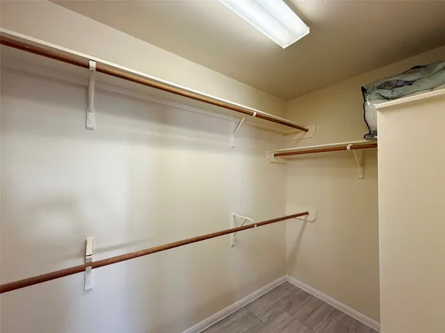 a view of walk in closet with empty racks