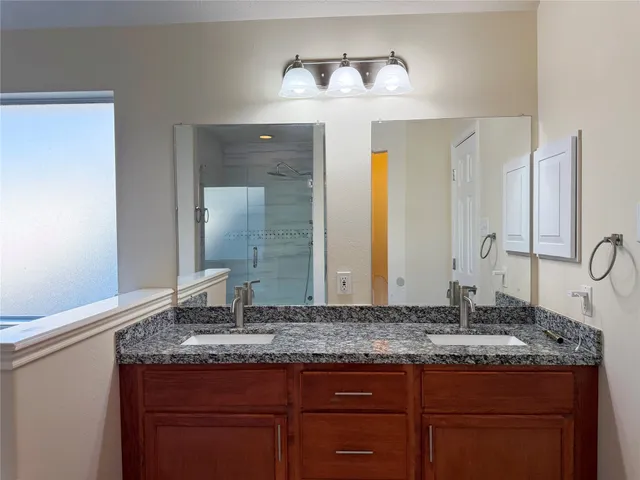 a bathroom with a granite countertop sink and a mirror