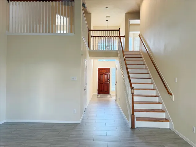 a view of a hallway with wooden floor and entryway