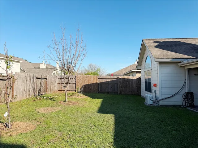 a view of a house with backyard and a tree
